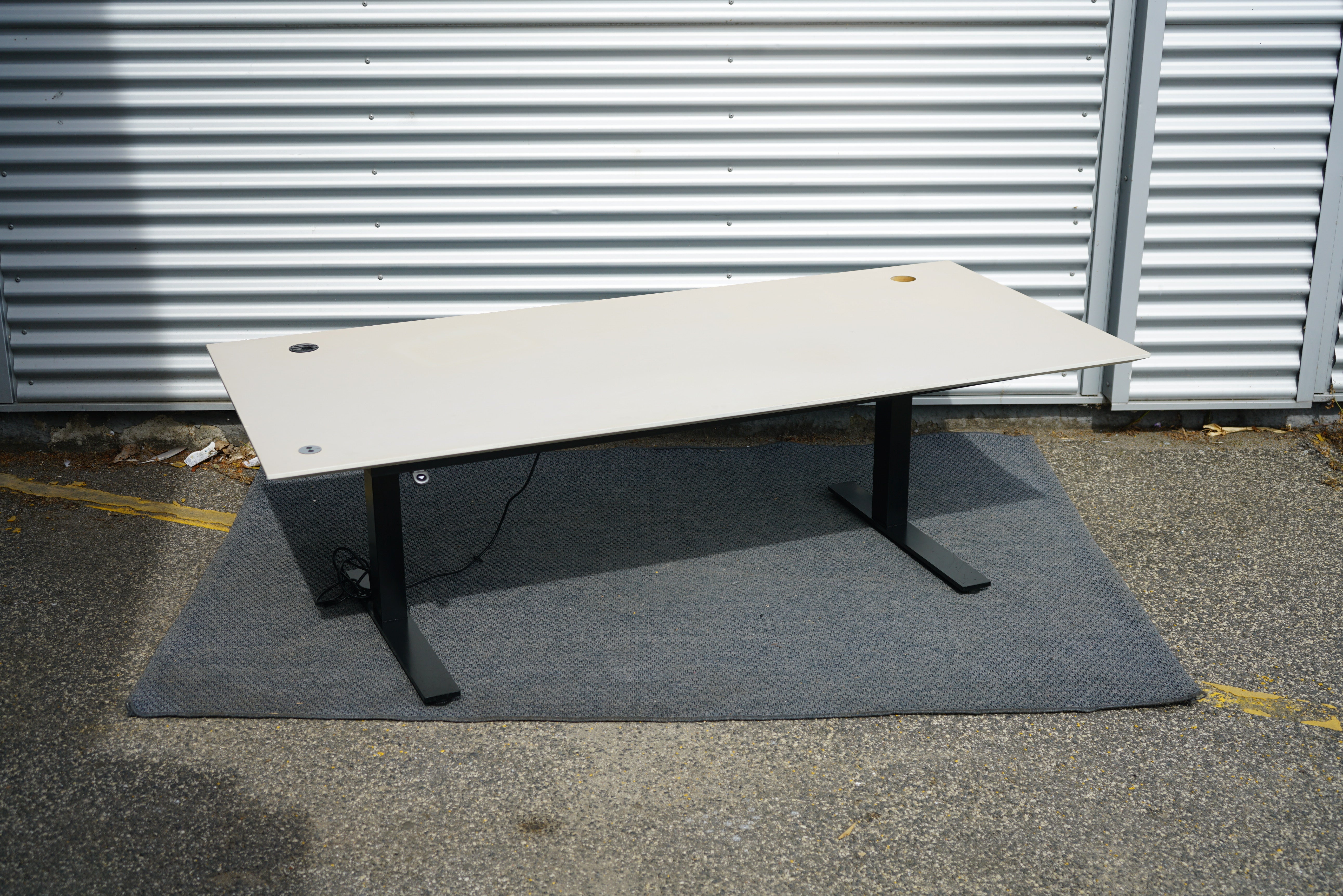 Rumas hæve-sænkebord 200x90 i beige linoleum med sort stel set fra skrå vinkel